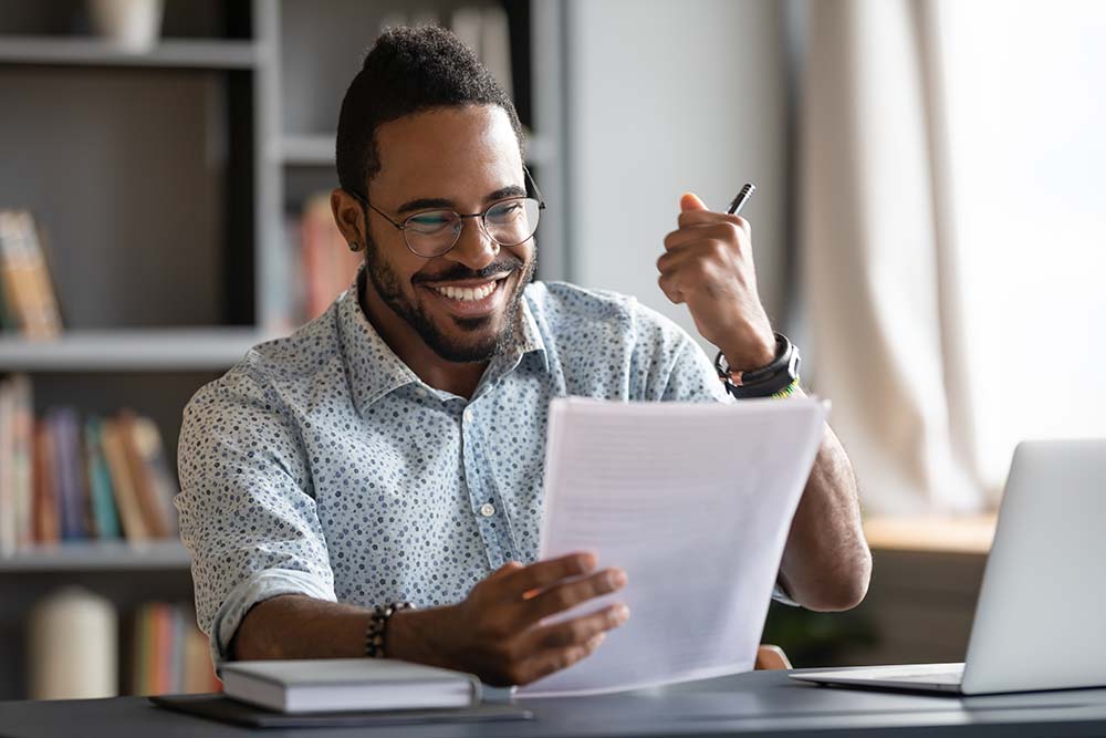 male student excited while reviewing papers 