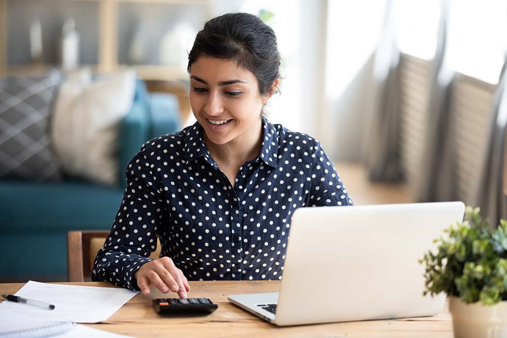 woman on laptop using calculator