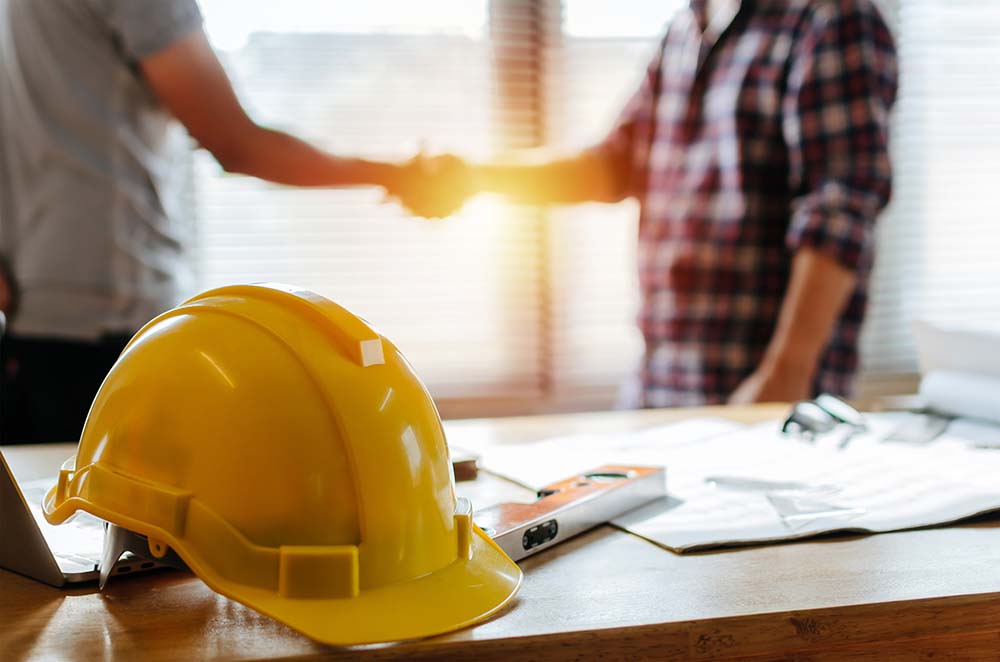 men in construction office shaking hands
