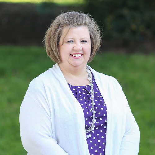 DCCU Lead Staff Development Specialist, Sandy, smiles outside in front of the camera