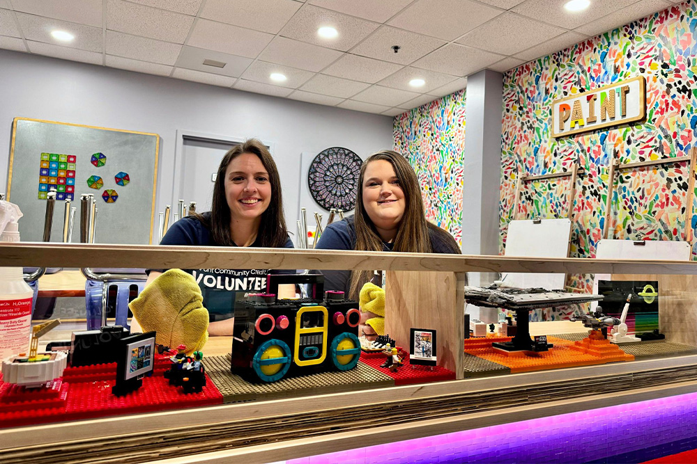 Two female DCCU employees pose for the camera during a morning volunteer shift at the Explore More Discovery Museum in Harrisonburg, Virginia. 