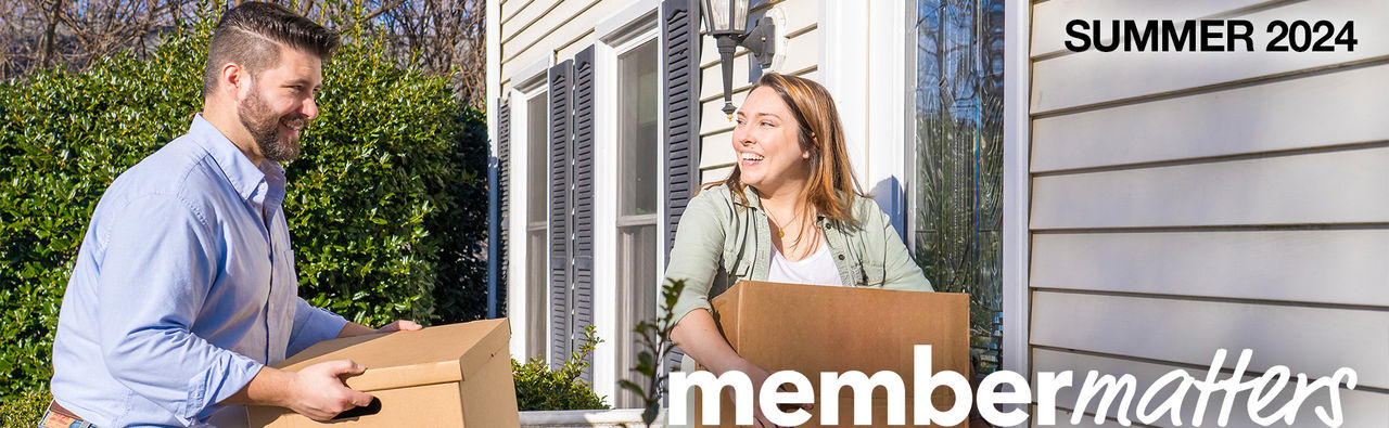 Couple moving boxes into house