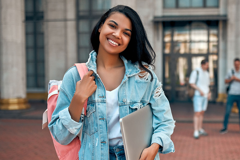 Young female college student holding laptop