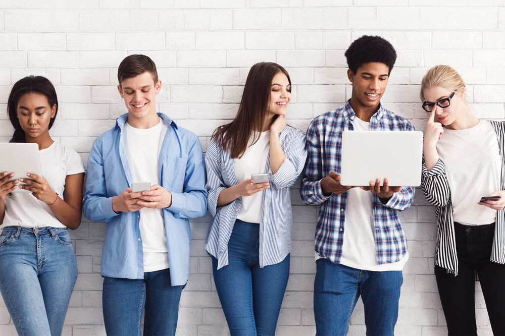 5 students looking at devices