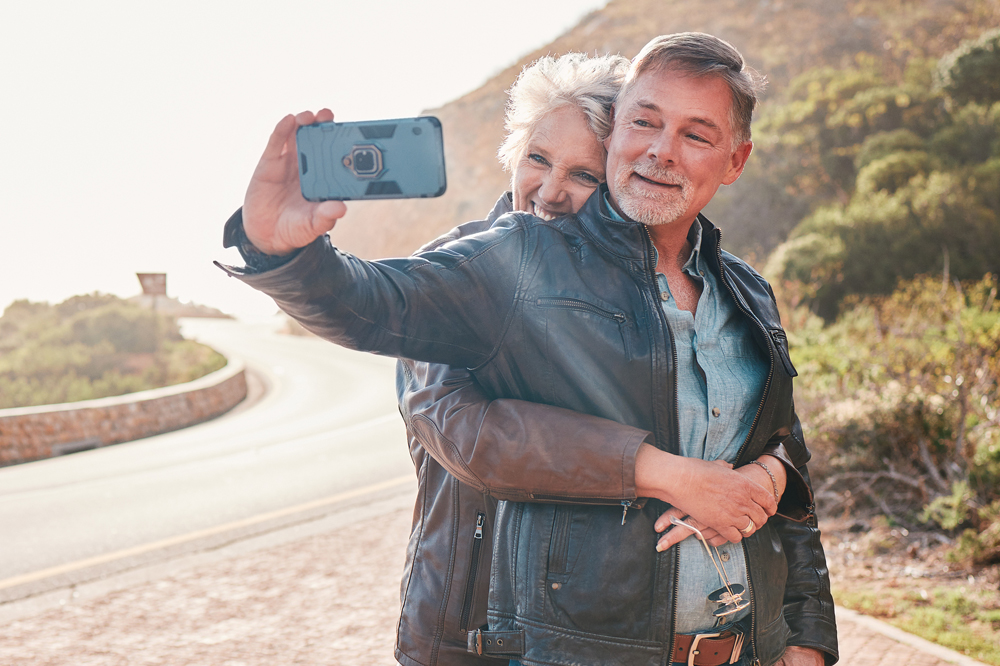 Happy couple taking selfie on side of street