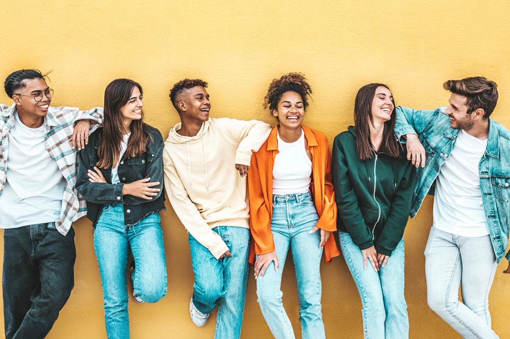 A group of students stand against a wall