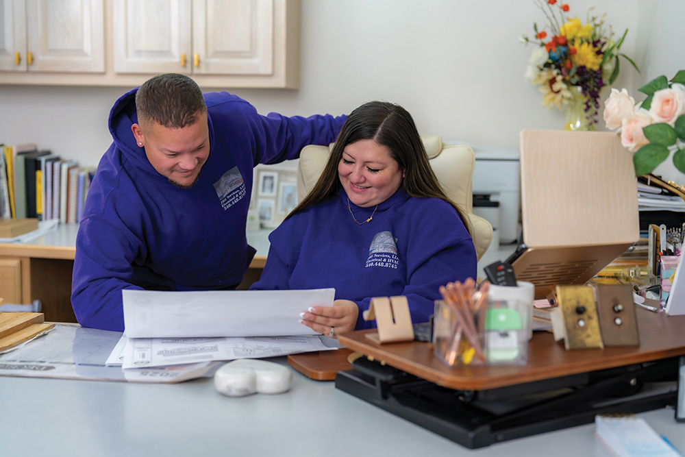 JBE Services owners, Elvis and Stefany Resto, go over paperwork together in their office. 