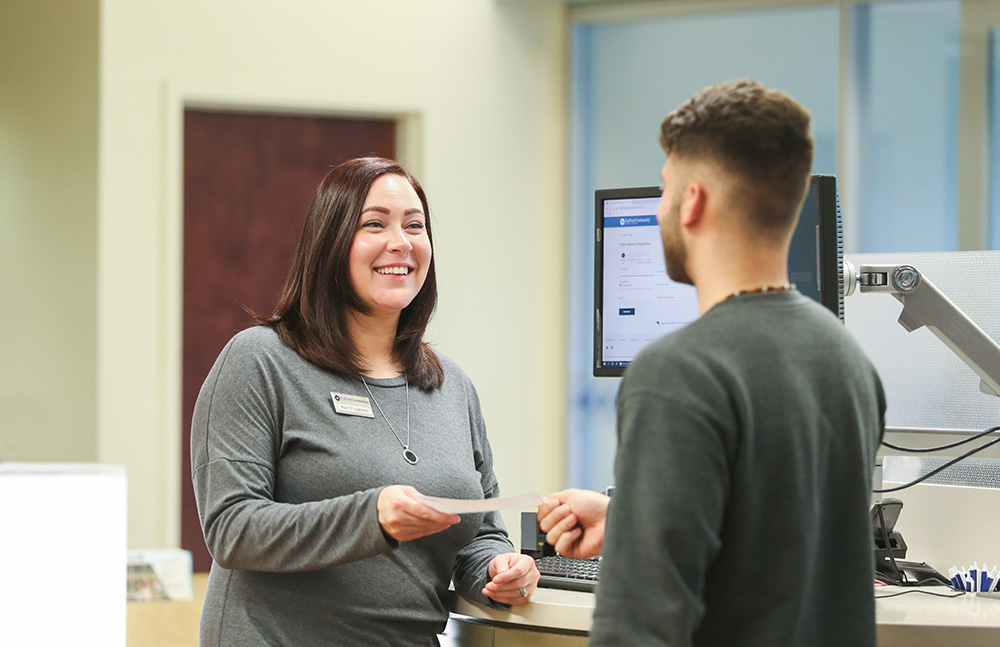 DCCU Employee assisting member with transaction