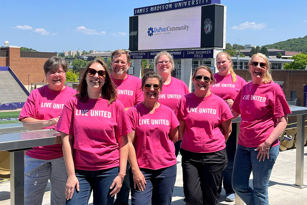 DCCU employees pose and smile for the camera as they volunteer with the United Way in their Day of Action 