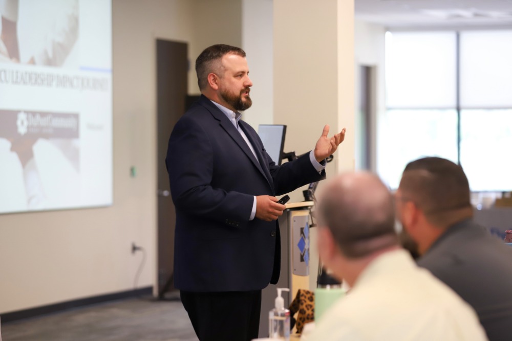 Kyle presents to a group of DCCU employees
