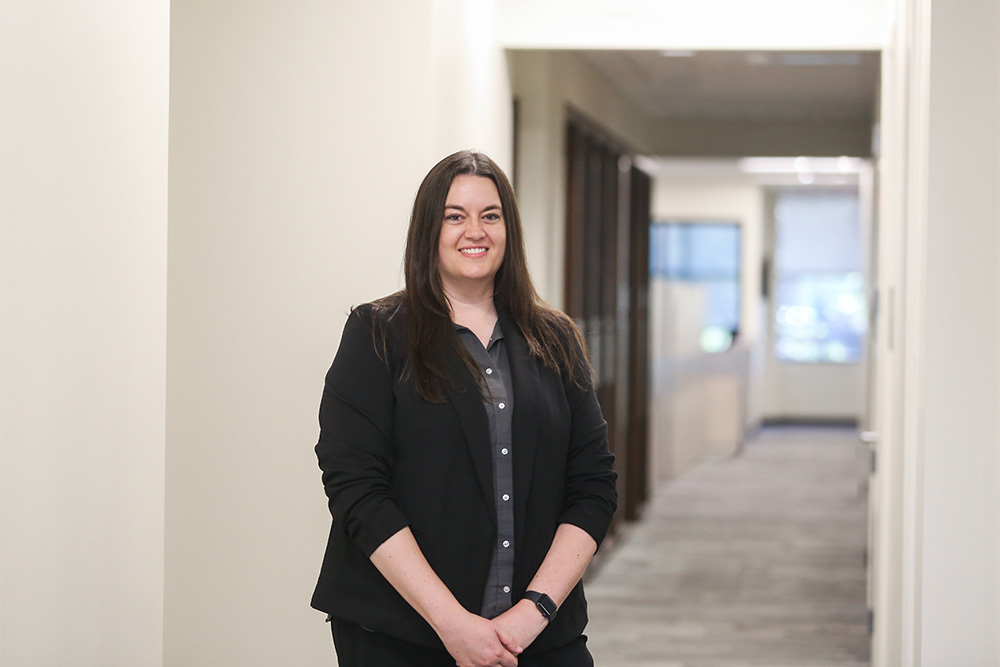 DCCU employee smiles and stands in hallway