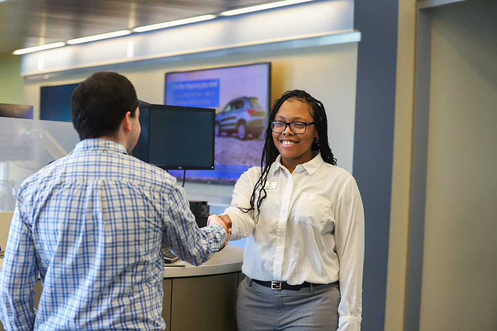 Man shakes the hand of a smiling DCCU female employee