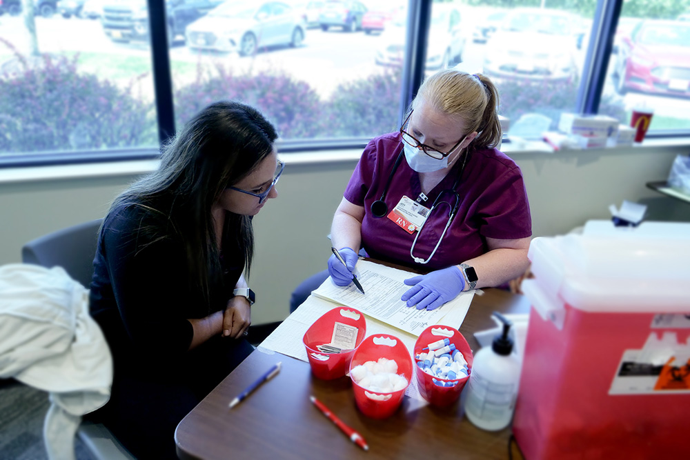 DCCU employee reviewing health screening with nurse