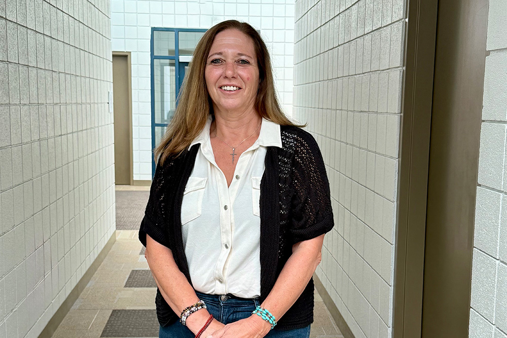 DCCU employee, Marsha, smiles for the camera from an office building 