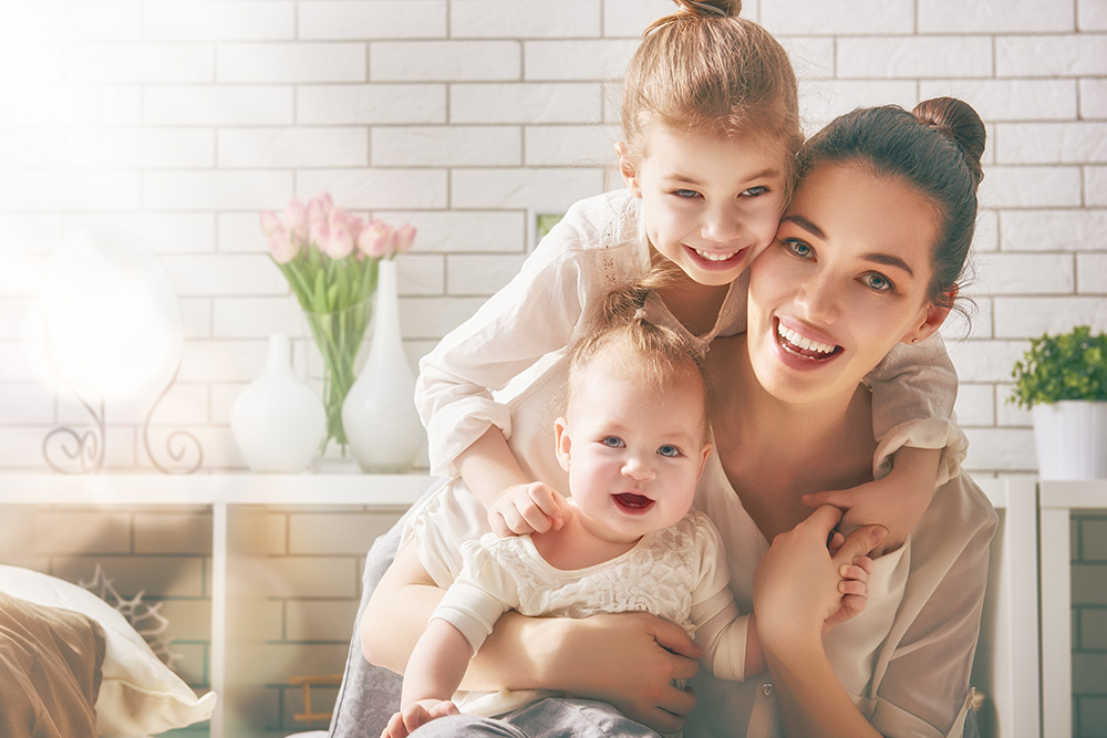 woman with two kids smiling