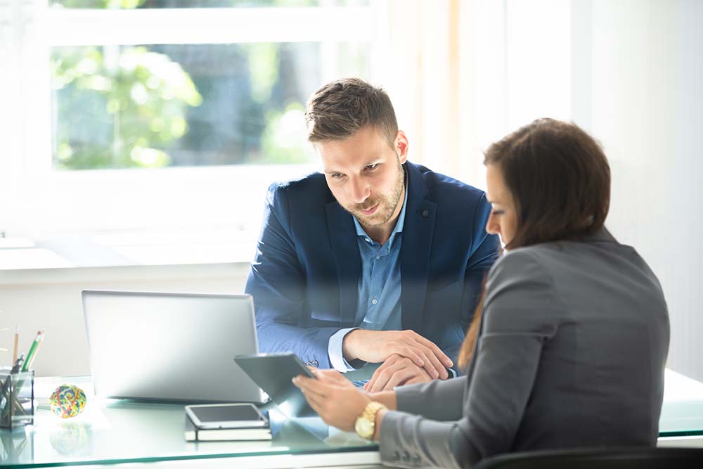 business man and woman looking at tablet together