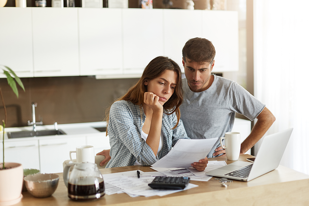 concerned couple reviewing financial documents together