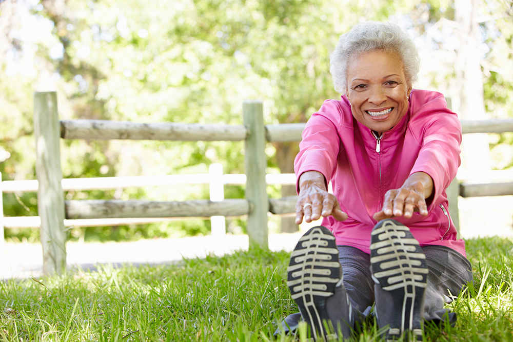 Elderly woman stretching outside happily