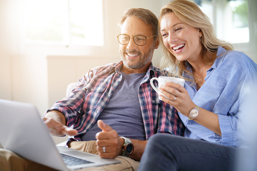 couple looking at computer together while drinking coffee