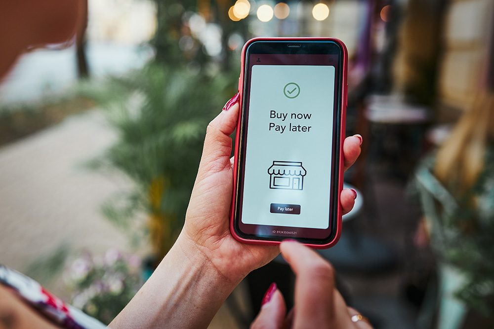 Woman holding phone with Buy Now Pay Later on the screen