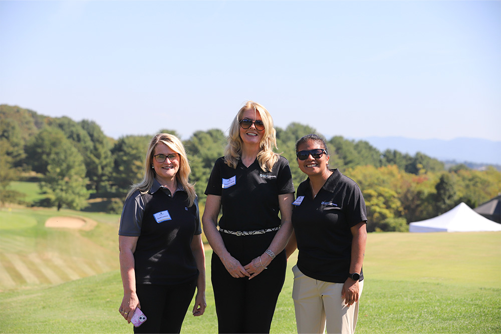 Sarah Landram, Margaret Hersh, and Jennifer Arteaga-Vargas, smile for the camera from the DCCU Cares Foundation 2025 golf tournament. 
