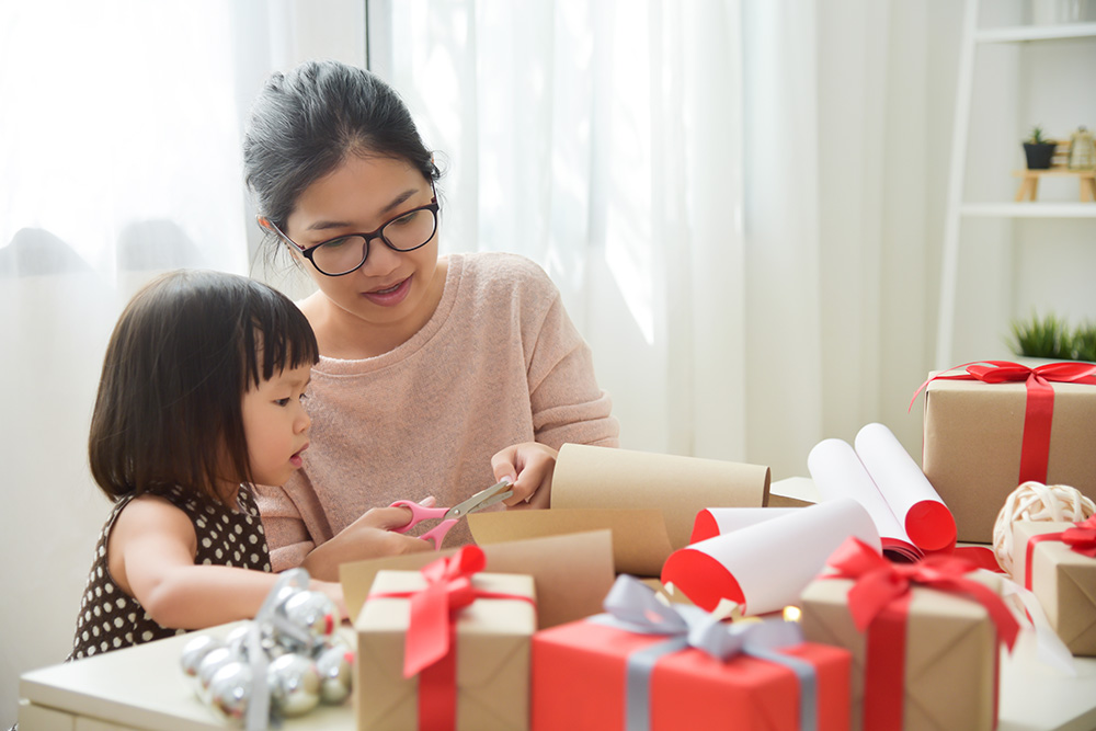 mom and daughter wrapping gifts together