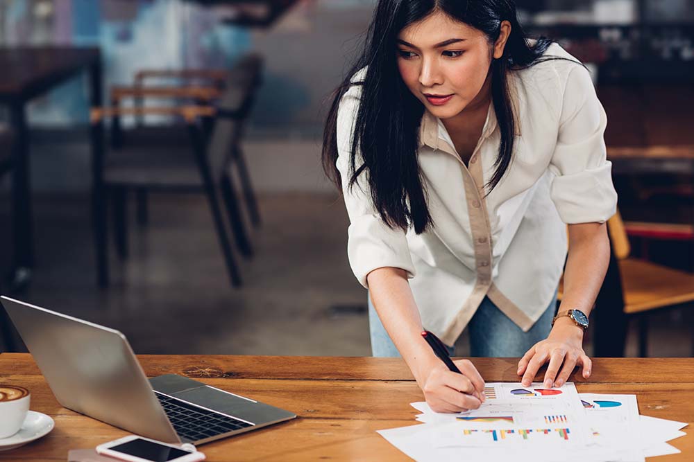 young woman reviewing reports and making notes