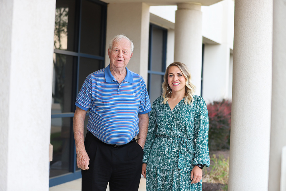 Everett Campbell, former DCCU Board Chair, and Angie Simonetti, current DCCU Board Chair, stand next to one another