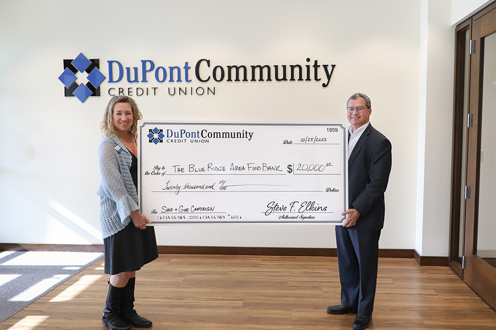 DCCU President/CEO, Steve Elkins, presents large check totaling $20,000 to Blue Ridge Area Food Bank Director of Development & Community Engagement, Millie Winstead.