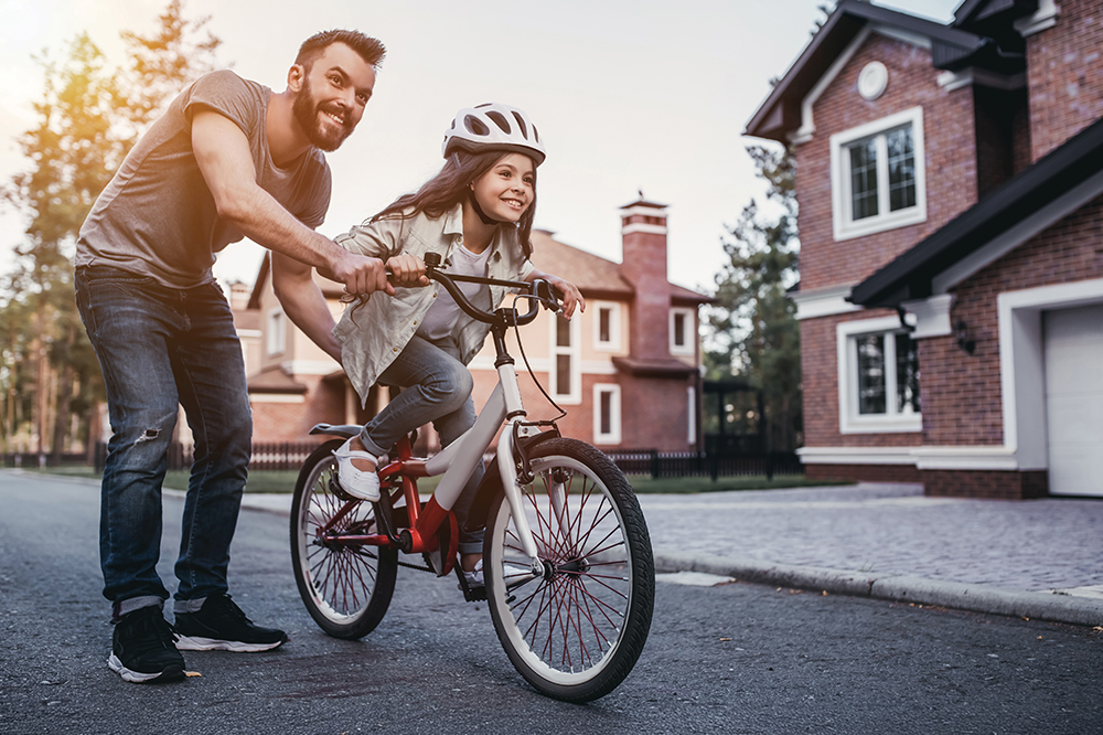 Dad teaching daughter to ride a bike