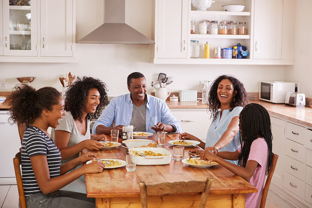 Family laughing at dinner table together