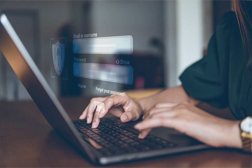 A woman's hands are seen typing on a laptop computer. There is a login box overlayed on the image.