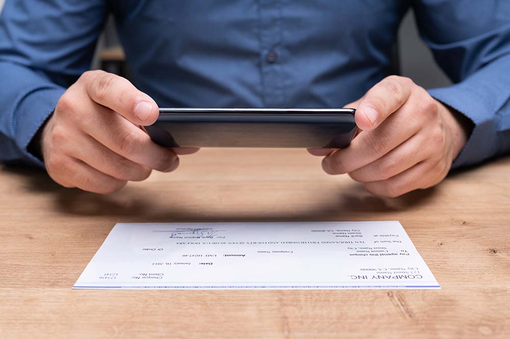 hands using phone to do a mobile deposit of a check