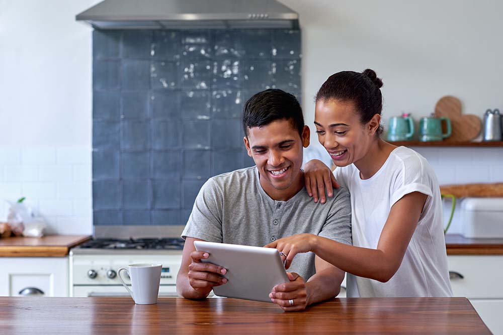 couple looking at tablet together in the kitchen