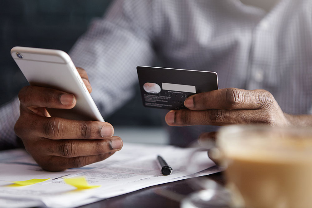 man making a purchase on a mobile device with a credit card