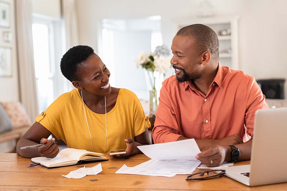 couple happily reviewing finances together in home
