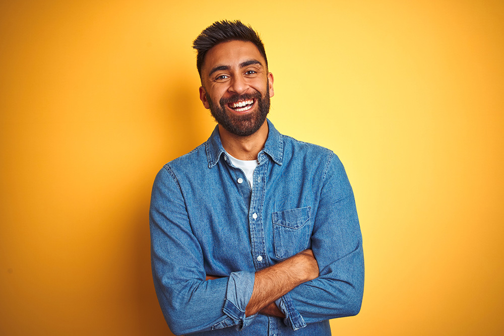 Happy man in front of yellow background