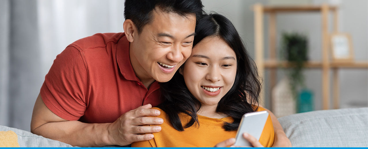 A couple smiling and looking at a phone