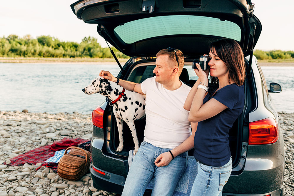 woman taking pictures with man and dog