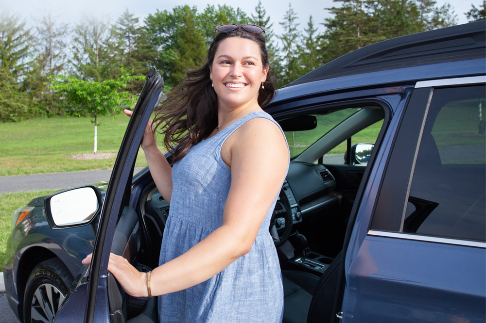 woman getting out of her car smiling